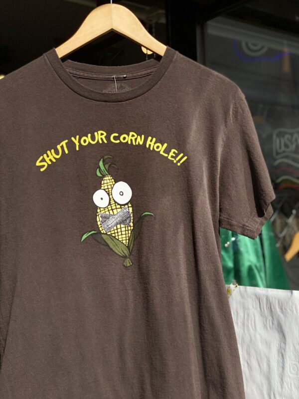 LOGOTEL "SHUT YOUR CORN HOLE!!" Tシャツ　Mサイズ　ダークブラウン　とうもろこし 茶色　半袖Tシャツ　カワイイ　キャラクターTシャツ 黙れ　スラング　焦茶色